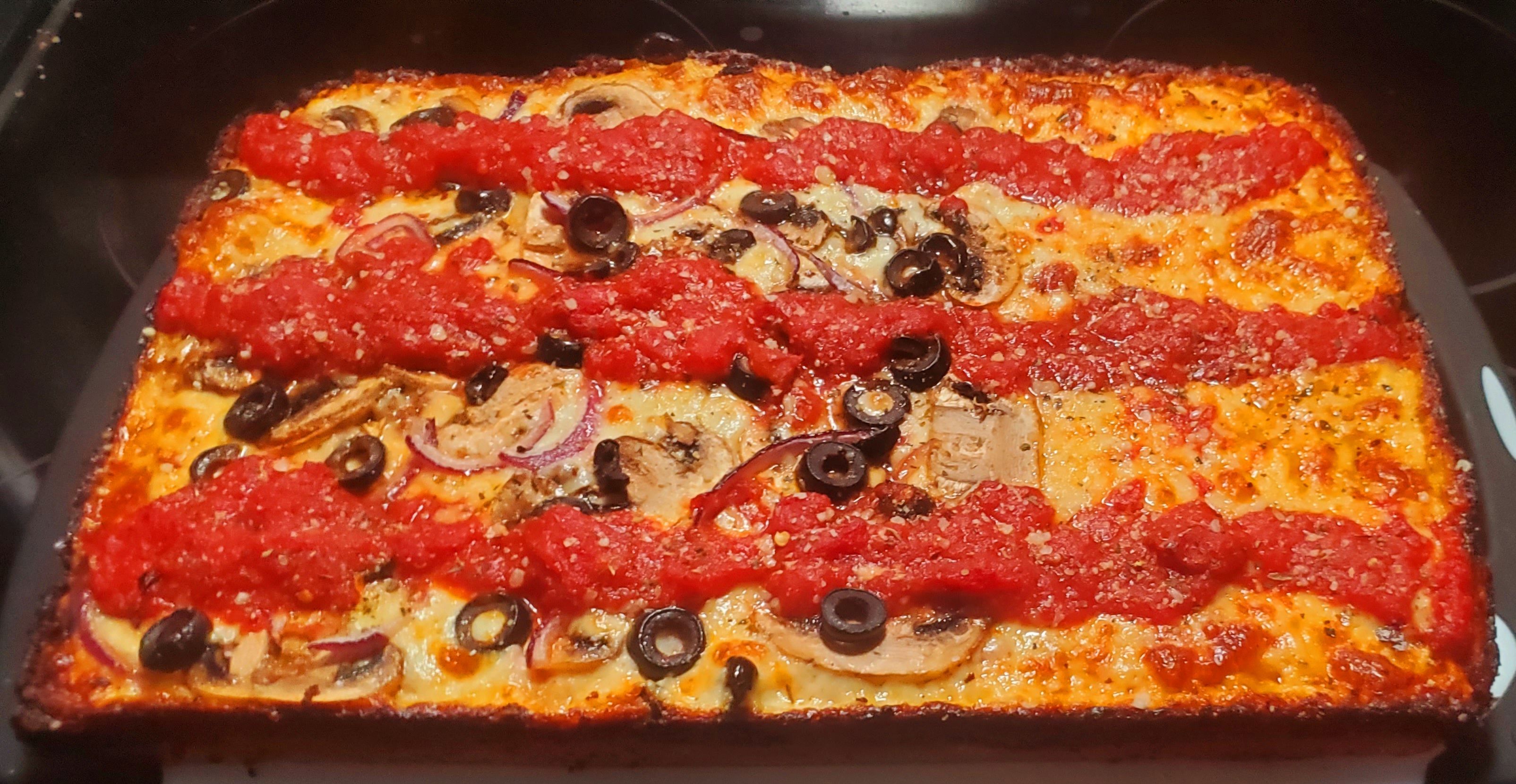 Detroit style. Cheese on the dough, sauce on top