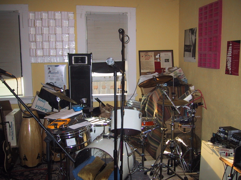 No-name *cheap* drums, packing material panels on the wall, timbales being used as tables/music stands